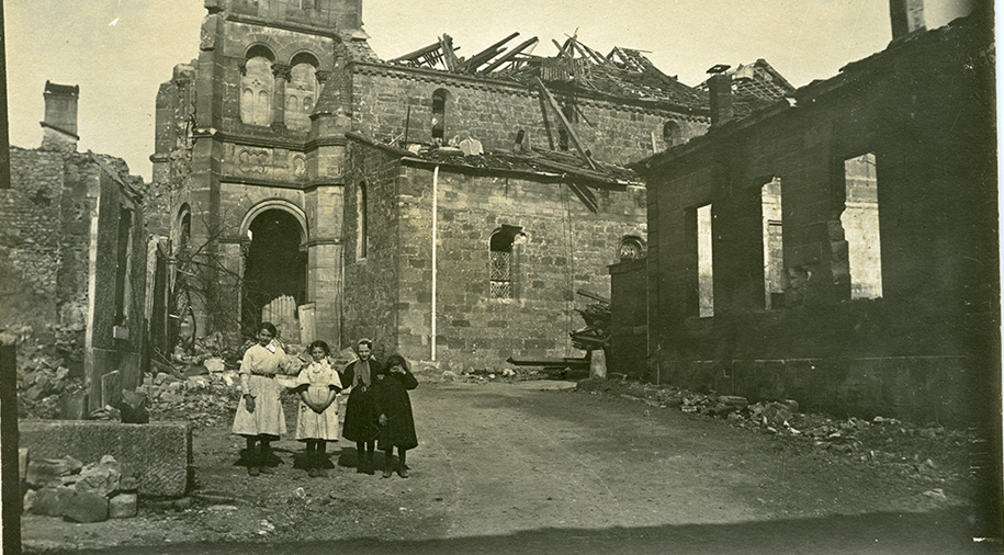 Photographie d'un groupe de fillettes devant une église en ruines