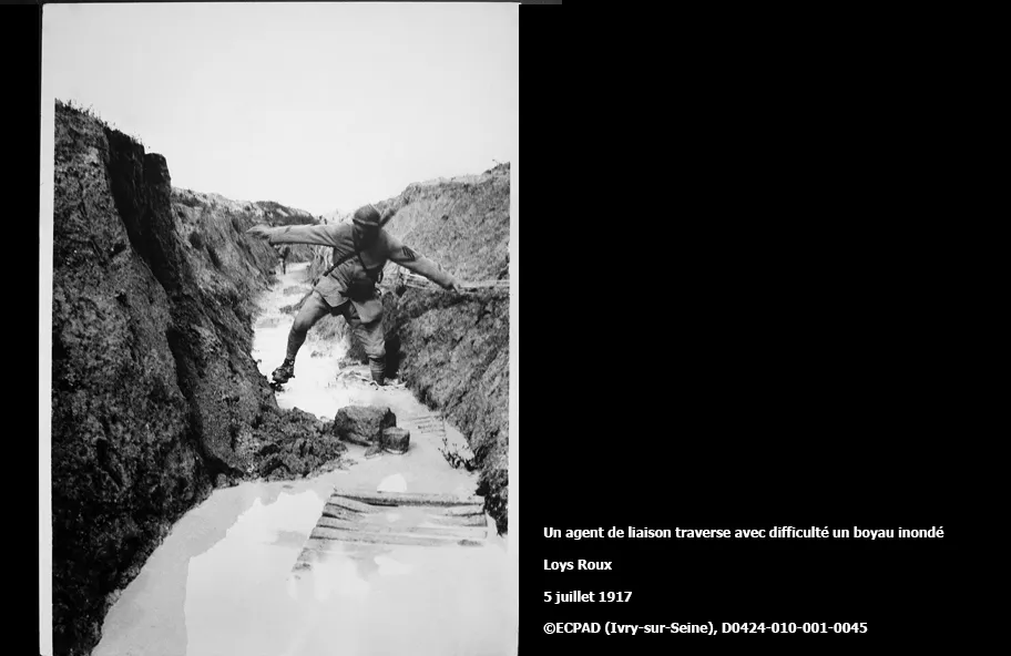 Un agent de liaison traverse avec difficulté un boyau inondé  Loys Roux   5 juillet 1917  ECPAD (Ivry-sur-Seine), D0424-010-001-0045